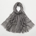 Macro shot of grey slub cotton scarf showing soft wrinkled texture and fine fringes - Grey