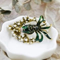 Detailed shot of an ornate goldfish brooch with green enamel and white pearls - DY18-Green Enamel Goldfish
