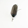 Detailed view of handmade feather brooch with black and white spots and green peacock sheen - Black With White Spots Guineafowl Style