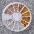 Macro-detail van een 12-vaks nagelkunst wiel met gouden en zilveren metalen kralen - Gemengde Stalen Kralen Schijf