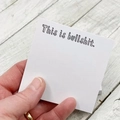 Bloc-notes adhésif humoristique avec texte 'This is bullshit' tenu à la main au bureau - C'est n'importe quoi