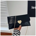 Details der glänzenden schwarzen Lackleder-Clutch mit goldener Herzschnalle und Kette - Schwarz