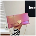 Detail der pinkfarbenen Metallic-Tasche mit herzförmiger Goldschnalle und Kette - Rosarot
