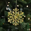 Golden snowflake Christmas ornament with hollow pattern on tree branch, 10x10cm size - Snowflake D