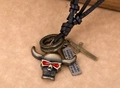 Dettaglio di collana in pelle vintage con teschio con occhi rossi e ciondolo croce bronzo - Teschio di Testa di bue
