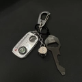 Dettaglio di moschettone argento, termometro, dadi e apribottiglie su trama scura - Set Bussola Chiave Nero (Con Dado Argento)