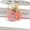 Close-up of pink resin letter O keychain with glitter, enamel bee, and leather tassel - Letter O Bee Keychain