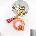 Detail of pink resin letter Q keychain with glitter, leather tassel and gold bee charm - Letter Q Bee Keychain