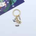 Detail of nautical keychain with golden anchor, lighthouse, and ship wheel charms - Anchor/Sailboat/Lighthouse/Rudder