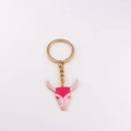 Close-up of pink bull skull keychain charm with golden metal ring and enamel detail - Pink Bull Head