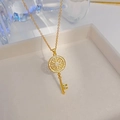 Elegante collana con ciondolo a chiave dorata in zircone su una scatola per gioielli - Chiave Magica / Oro