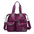 Primer plano de la tela oxford morada impermeable y el detalle multibolsillo del bolso - Morado