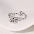 Anillo de flor minimalista con banda plateada texturizada y diseño abierto - Color Acero