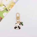 Dettaglio del ciondolo a forma di panda e bambù in smalto con finitura dorata sul portachiavi - Panda con bambù