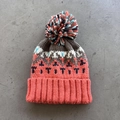 Detail of multi-color knitted beanie with geometric pattern and fluffy pom-pom top - One Size / Coral Orange