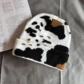 Detailed knit texture of vintage black and white cow print beanie on a grey background - One Size / Large Black & White Cow Print