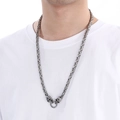 Detalle de collar de cadena bizantina plateada con calaveras en un modelo masculino - Estilo Color Acero (KN113573-Z)