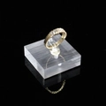 Macro di un anello dorato con zirconi incastonati su espositore in acrilico trasparente - 4*4*1.2CM / Base Smerigliata
