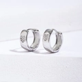 Macro view of wide hoop earrings with micro-inlaid heart zircon stones in silver - 11mm / Silver