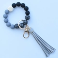 Close-up of leopard print silicone beads with grey tassel and golden keychain ring - Tech Gray
