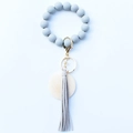 Detailed macro view of beaded wristlet keychain with leather tassel and gold ring - Gray