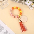 Colorful silicone bead wristlet keychain with wooden disc and leather tassel detail - Yellow Orange Purple Pattern