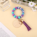 Vue détaillée d'un porte-clés en perles de silicone avec pompon violet et bois poli - Marbre Violet Cyan