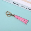 Pink PU leather tassel keychain with gold ring on a blue background with a book - Pink 2