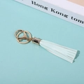 Close-up of light blue PU leather tassel keychain with gold alloy rings on magazine - Light Blue
