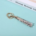 Detail shot of golden metal keyring with beige snakeskin pattern leather tassel pendant - Snake Pattern