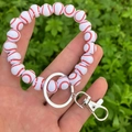 Detailed close-up of a white wooden baseball bead bracelet keychain with metal clasp - White Baseball