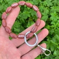 Detail of beaded American football keychain wristlet with silver metal ring and lobster clasp - Brown Football