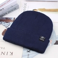 Detailed knit texture of navy blue winter beanie with rectangular decorative logo tag - Blue (TF Label)
