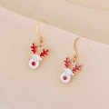 Detailed macro view of festive Christmas reindeer drop earrings in red and white enamel - Red White Reindeer
