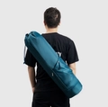 Dark teal yoga mat bag with drawstring top and side zipper pocket shown on model - Blue