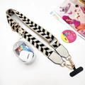 Detail of adjustable patterned phone strap with a transparent zipper pouch and gold clips - Beige Leaf Strap With Pouch And Tab