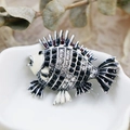 Macro detail of a fish brooch with black and white rhinestones on a ceramic dish - DY17-Black White Striped Fish