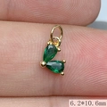 Macro shot of gold pendant with green zircon heart, size 6.2x10.6mm detail on fingertip - Green