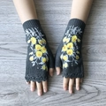 Grey fingerless knitted gloves with yellow flower embroidery on a wooden table - Dark Gray