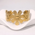 Bracciale rigido floreale vintage in acciaio dorato su supporto bianco elegante - Oro