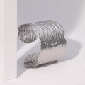 Moderner unregelmäßiger silberner Manschettenarmreif aus Edelstahl mit Metallstruktur - Stahlfarbe
