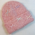 Close-up of pink knit beanie featuring delicate ribbon bows and thick ribbed texture - Pink