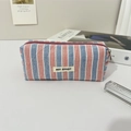 Dettaglio della borsa da toilette in tela a righe rosse e blu con cerniera viola - Astuccio a Righe