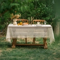 Ivory crochet lace tablecloth with tassels on a wooden garden table in outdoor setting - Wavy Semicircle Flower with Tassels