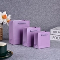 Trio of purple paper jewelry gift bags in three sizes on a rustic textured surface - Pearlescent Vivid Purple