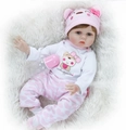 Realistic reborn baby doll in pink heart onesie and bear ear hat on white blanket - Wig Style