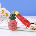 Rosa Ananas Schlüsselanhänger mit Strasssteinen und Kristallband auf weißer Tastatur - Rosa