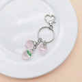 Nahaufnahme von durchsichtigen rosa Erdbeer-Anhängern an einem silbernen Schlüsselring - Rosa Erdbeere (Mit Schlüsselanhänger)