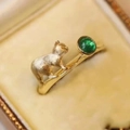 Macro shot of vintage emerald ring with 3D gold cat detail on brushed metal band - Adjustable Open / Cat Style