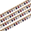 Close-up of golden enamel bead chain with red, blue and grey charms for DIY jewelry making - Multicolor